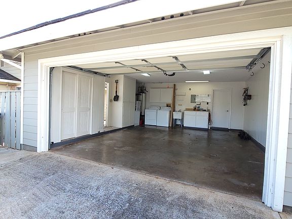 2 car enclose garage w/remote, full size washer-dryer, a laundry tub, small stand-up freezer and lots of cabinets for storage. To left of picture is an access door to outside patio area.