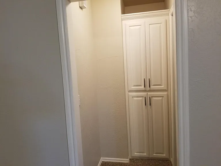 Linen cabinets in hallway off of living room that leads to master bedroom.