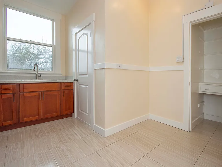 Another view of kitchen; walk-in pantry to right (shelves are being added); space for a kitchen table in center