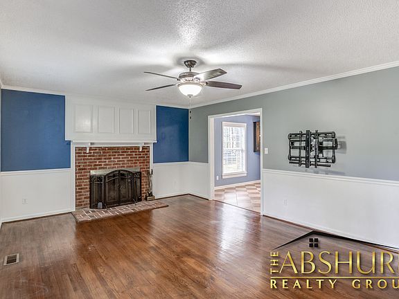 Living room. Hardwood floors, TV wall mount, wood burning fireplace, custom trim, built in bookshelf