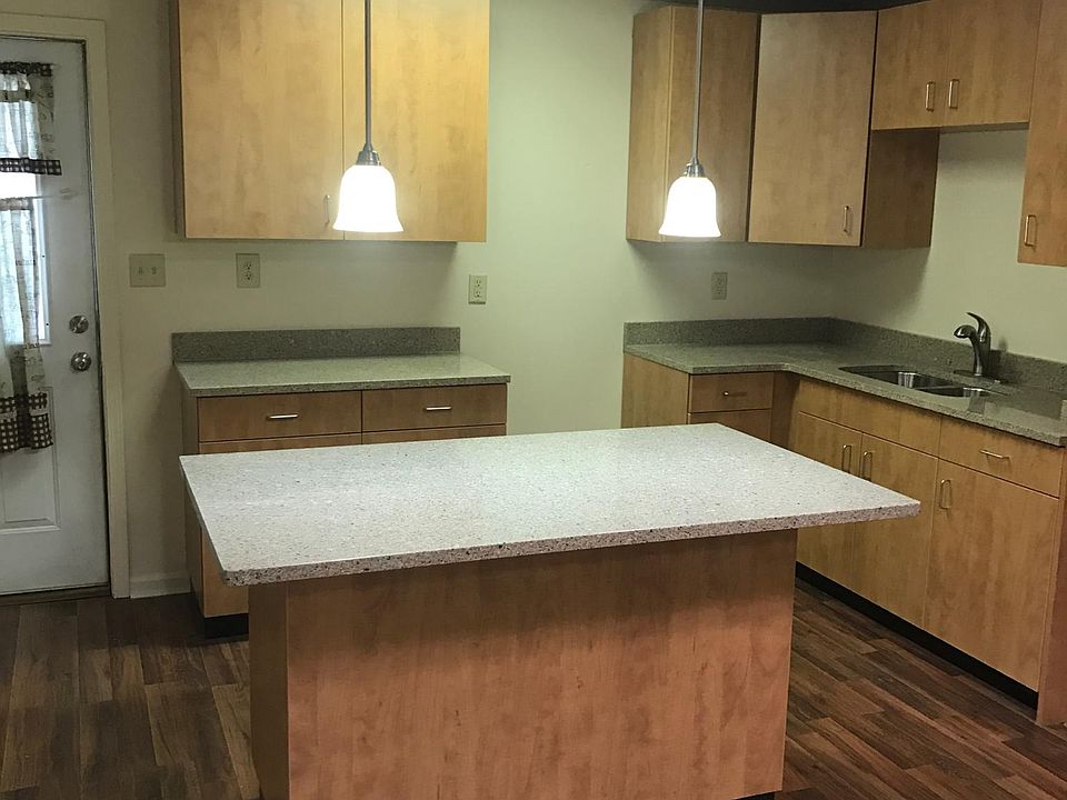 Kitchen with custom built center island with stone counterto