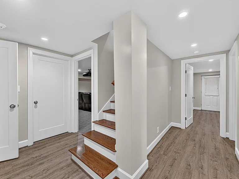Basement stairs to home theatre room, laundry room, full bathroom, guest bedroom.