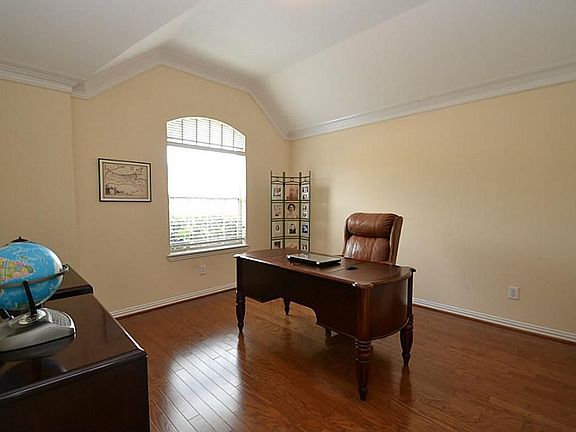 French door opening to the study offering hardwood floors, double crown molding and raised ceilings.