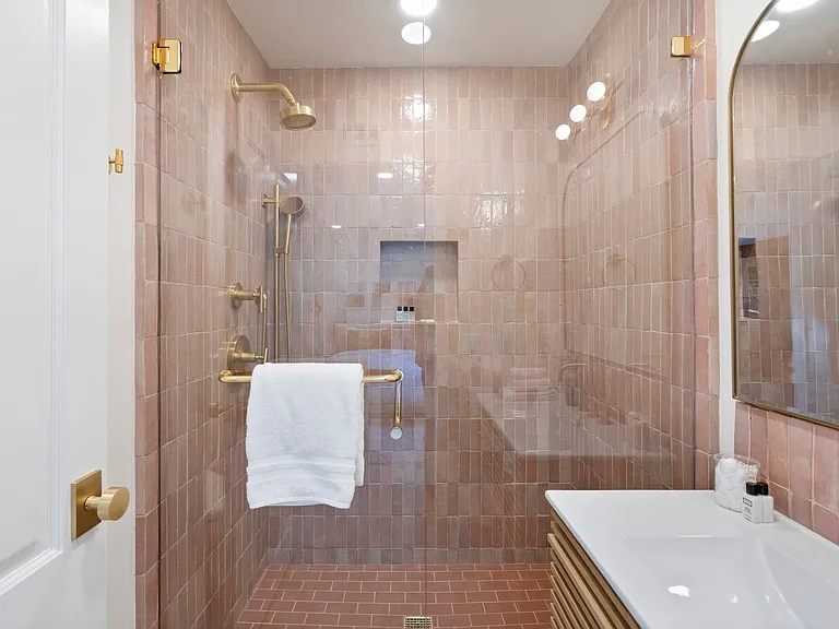 A shower that wraps you in rich texture and soft, rosy hues.