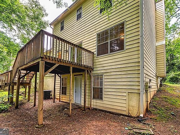 Exterior back view of home showing a large wood deck and the partially finished walkout basement.