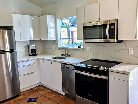 All-new kitchen with high gloss frameless cabinets, quartz countertops and backsplash, dishawasher, microwave, refrigerator and range.