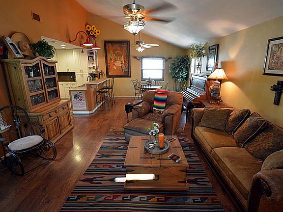 Absolutely stunning living area with warm colors, tall ceilings, and laminate floors.