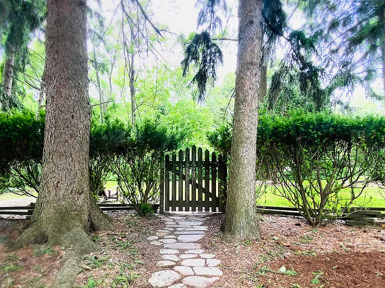 A charming stepping stone path leads to a secondary backyard, ideal for immersing yourself in nature and enjoying quiet moments of relaxation.