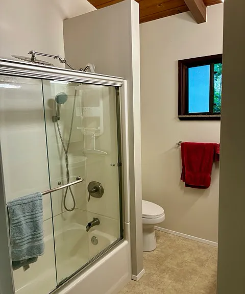 Full Tub Shower bath Toilet has bidet accessory counter top is Silestone Quarts and adjacent towel storage