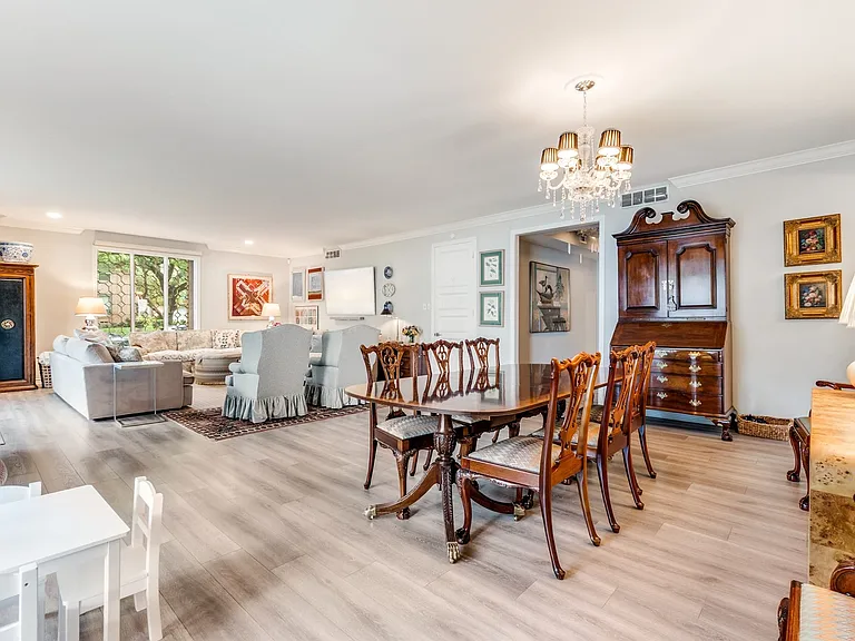 Open-concept living and dining areas featuring wood-finish flooring, recessed lighting, and crown molding