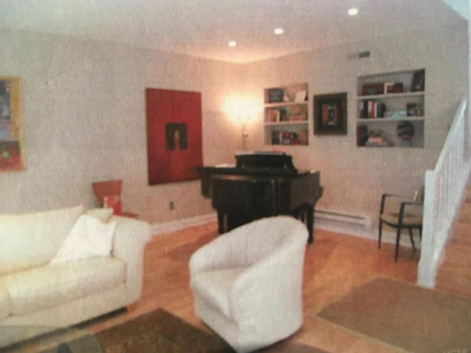 Living room with built-in book cases and baby grand piano