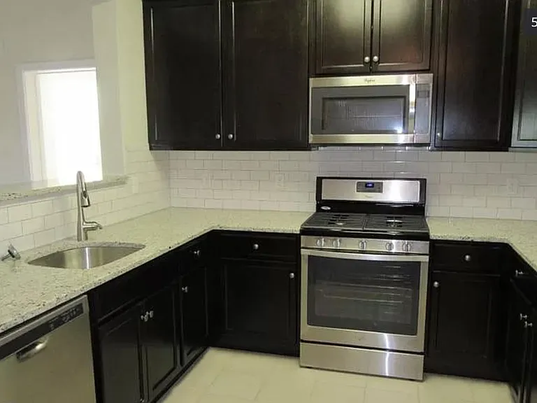 Kitchen with appliances. Oven, microwave, refrigerator, and dishwasher.