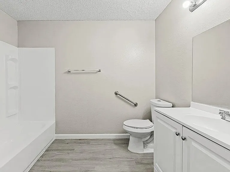 Bright, modern bathroom featuring a sleek bathtub, elegant vanity, and stylish flooring.