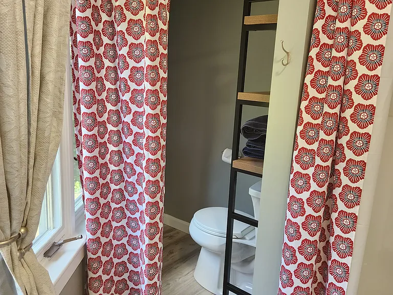 Bedroom 3 with queen bed on second floor, separate entrance, mini-fridge, mircowave, smart TV, fold away table and chairs, shower stall, bathroom sink, toilet, and views of backyard.