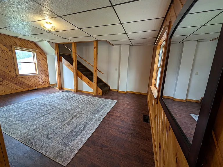 Large Living Room with lots of windows and stairs to second floor