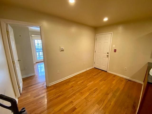 Living room with door leading out to side alleyway (alleyway has an additional lock on the chain link fence leading in and out).
