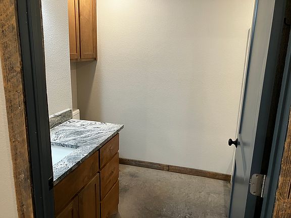 Bathroom with granite counter top and wood cabinetry