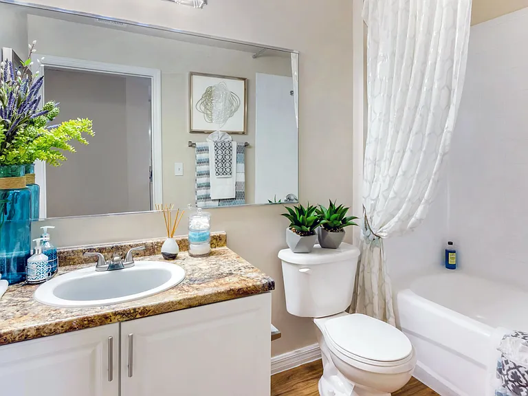 Elevate your daily routine in a bathroom that boasts rich Mascarella granite-style counters, large mirrors, and neutral tones.