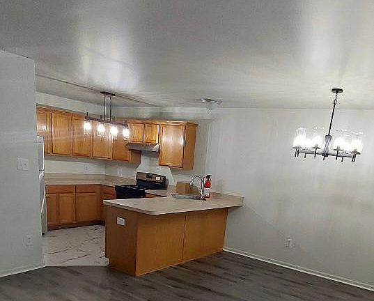 Kitchen & dining area with new Nucor tiles; new LED chandeliers and new stainless steel appliances.