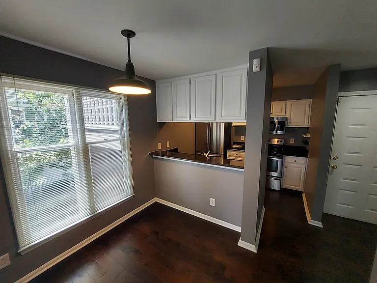 Bright dining room with granite serving countertop.