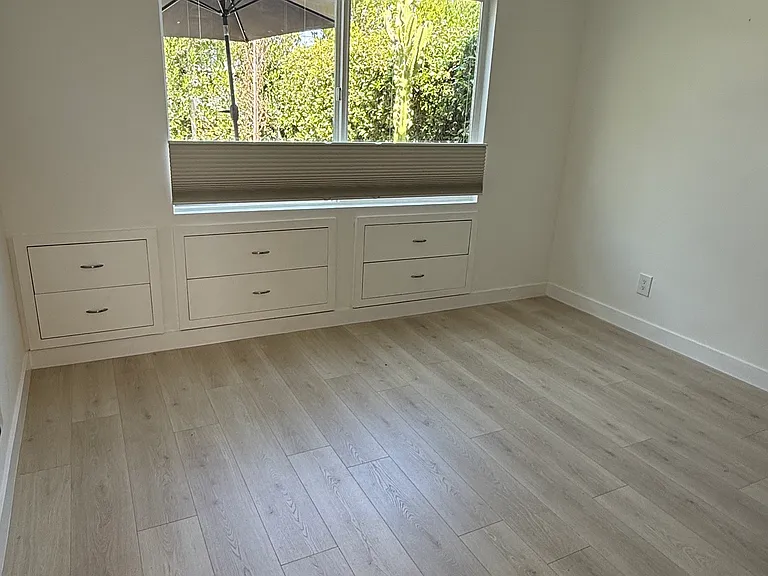 Primary bedroom with built in drawers and new floors
