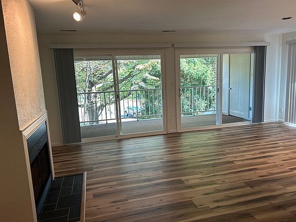 LIVING ROOM /DINING AREA- NEW LUXURY VINYL FLOORING. FRESH PAINT. NEW VERTICAL BLINDS ON ALL WINDOWS/SLIDERS. GAS FIREPLACE