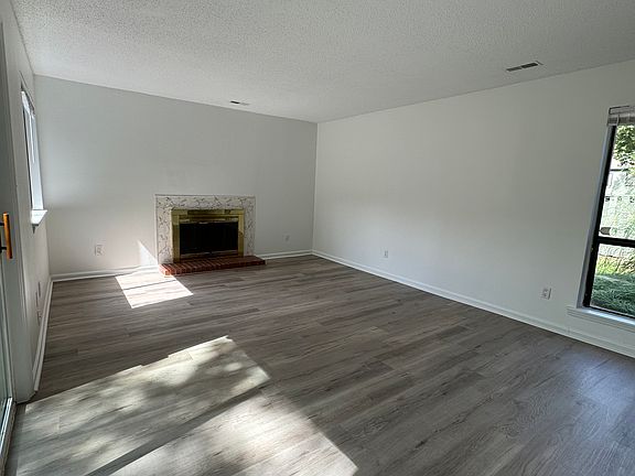 Den with fireplace. Note lots of light and LVP floors throughout.