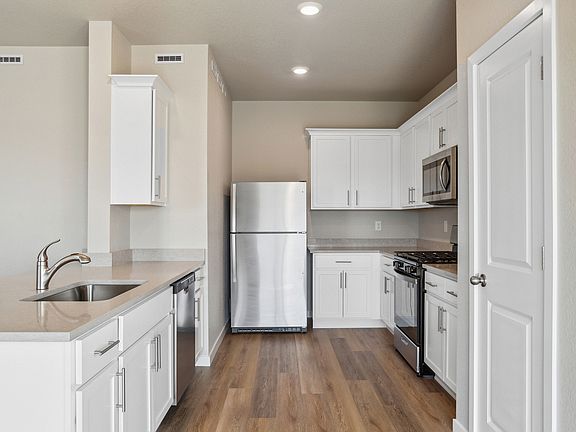 The kitchen has stainless steel appliances and white cabinets.