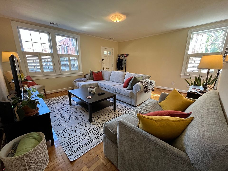 Living room with lots of space and windows with shutters for privacy.