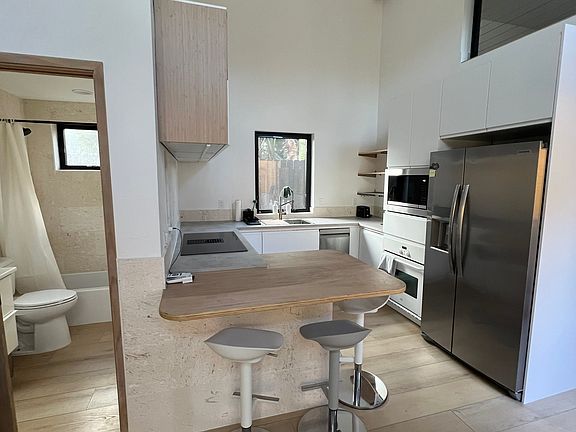 Kitchen and entry to bathroom with storage area above bathroom