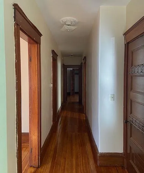 hallway w/lvng room, dining room and kitchen to the left, bedrooms and bath end of the hall & on right