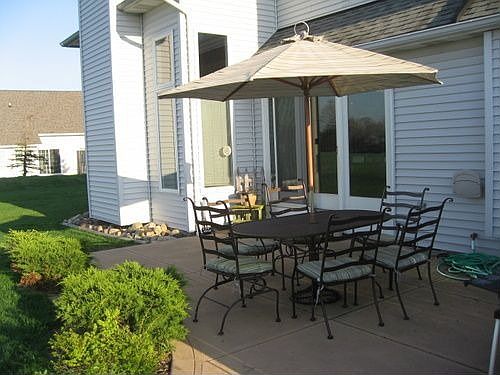 Large back yard features concrete patio and beautiful landscaping