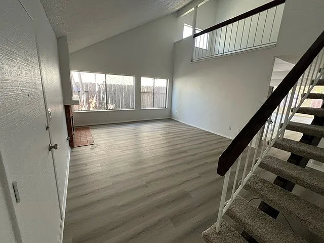 Living room with stairs leading up, balcony from upstairs family room visible in this picture