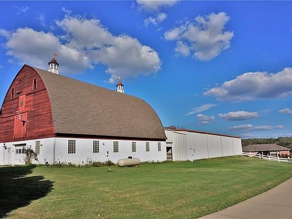 Arched roof 2 story barn with 4 stalls, heated office, bathroom with shower, tack room, and second floor has many possibilities!