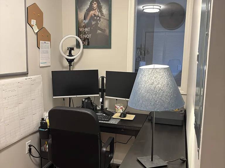 Office complete with L-desk and chair, two monitors, and printer.