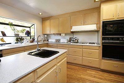 Large kitchen with garden window, island, and two sinks.