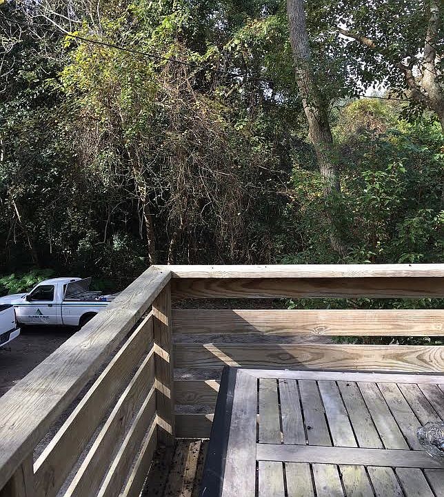 Nice back deck surrounded by greenery.