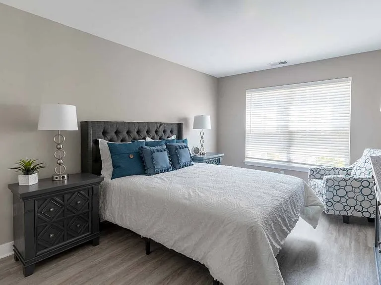 View of spacious bedroom with plank flooring, large windows