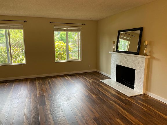 Light, bright & stylish living area has new Acacia flooring, brick fireplace and picture windows that overlook front yard.