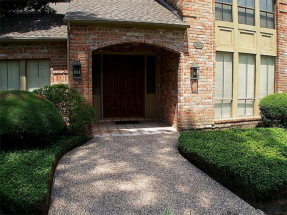 Well-manicured landscaping invites you into this lovely home.