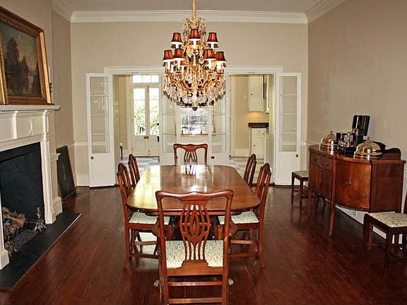 Formal Dining Room with a Fireplace & 2 Sets of French Doors opening to Kitchen