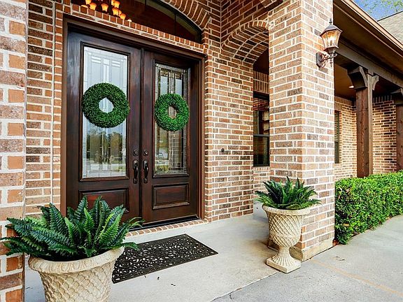 A covered front porch with a double-door entry greets you as you approach the home.