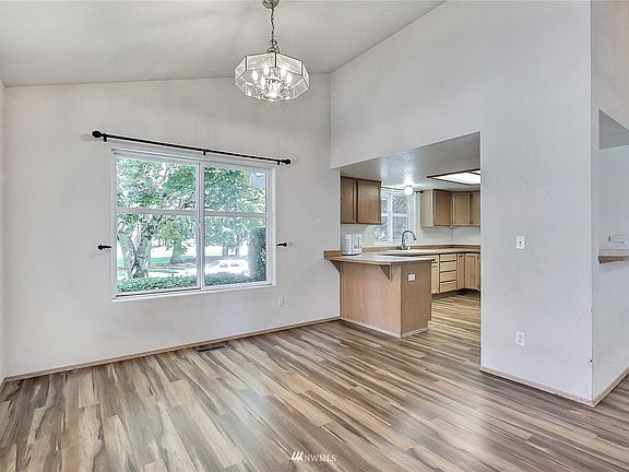 View of dining leading to kitchen, cathedral ceilings add a nice, open, airy feel to the first floor. 