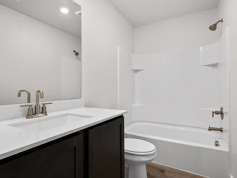 The secondary bathroom has a sprawling vanity and shower-tub combo.