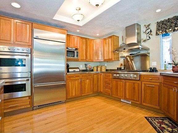 Epicurean kitchen w/natural cherry cabinets, brushed stainless steel counters.
