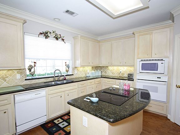 Island kitchen with granite and undermount sink.