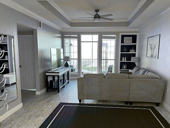 Open floor plan with crown molding and built-in shelving