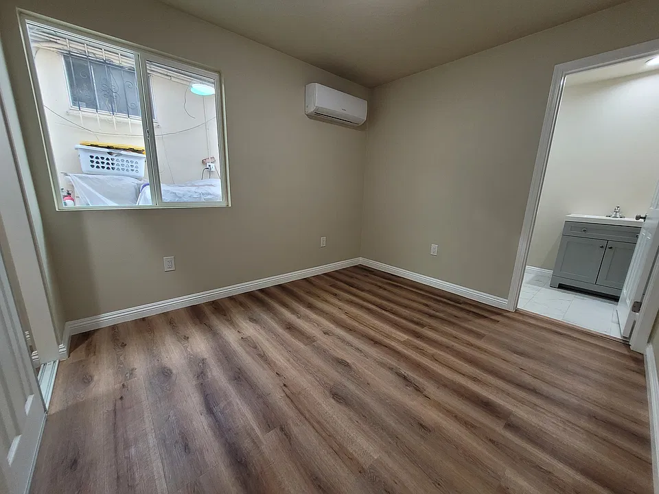 Master bedroom with mini-split air conditioner, closet, and bathroom