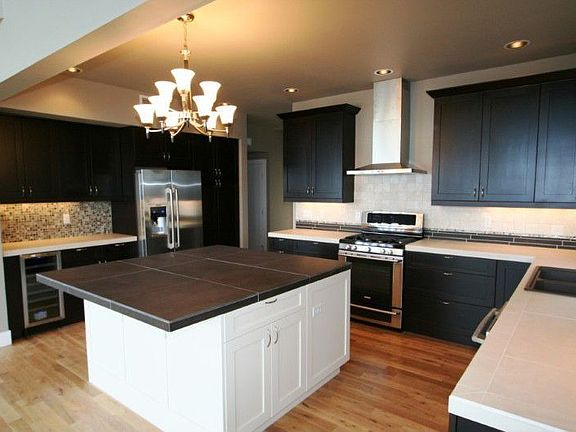 Beautiful kitchen w/ porcelain tile countertops, stainless appliances, wine fridge