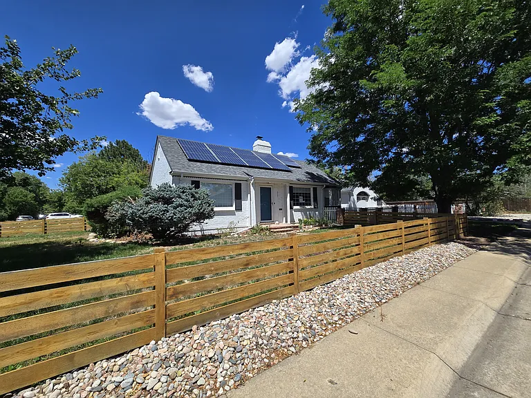 Low fence surrounds the corner lot, providing a large fenced in front yard, Solar offsets energy bills
